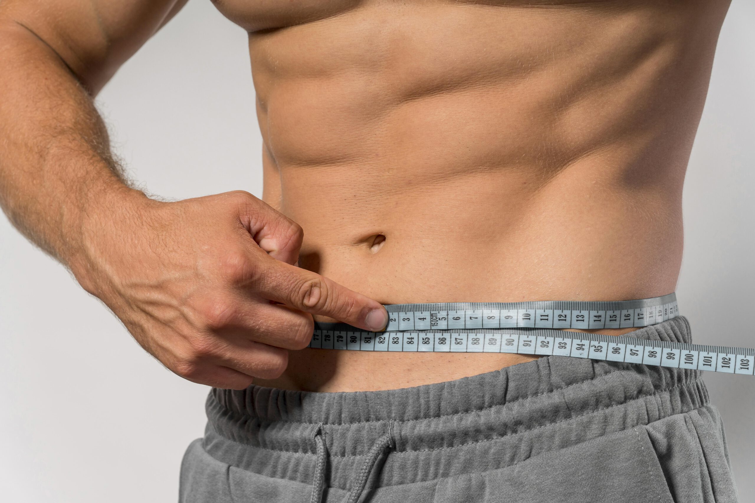 fit-man-holding-measuring-tape-around-waist